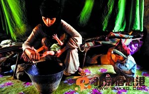 一位过早步入婚姻的14岁少女已经有两名孩子。图为少女为刚出生的婴儿洗澡(资料照片)。