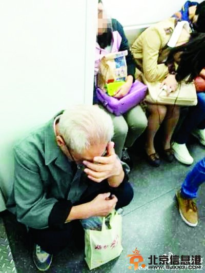 在地铁里一位白发老爷爷没有座位，只能掩面蹲下。（网友夏先生）