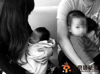 夫妻俩各抱着一个孩子到警局接受调查
