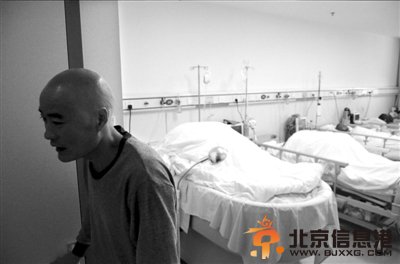 父亲李明为接受手术剃成了光头，离开病房准备去手术室。 京华时报实习记者摄/视频