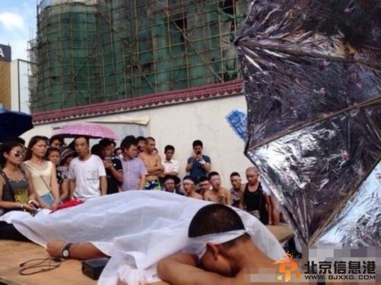 8月3日下午3点，湖北武汉中山大道佳丽广场，十多名赤膊男子披麻戴孝，用门板抬着一具“尸体”在此示威，宣称城管打死人。