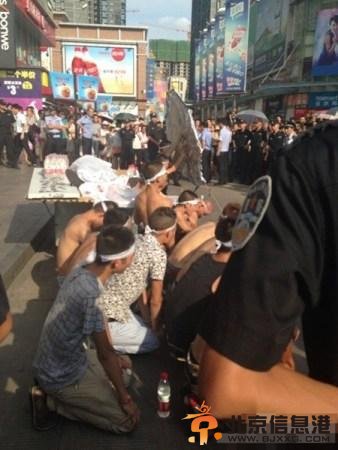 8月3日下午3点，湖北武汉中山大道佳丽广场，十多名赤膊男子披麻戴孝，用门板抬着一具“尸体”在此示威，宣称城管打死人。