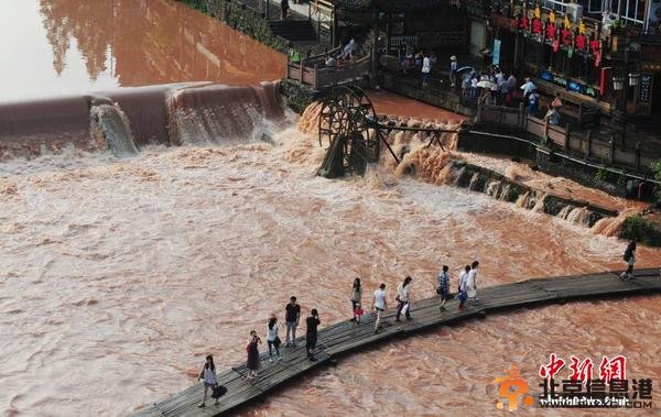 暴雨致凤凰古城内涝 游客洪水中留影