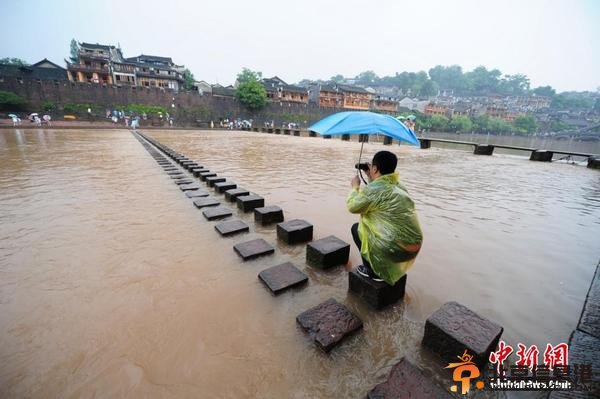 暴雨致凤凰古城内涝 游客洪水中留影