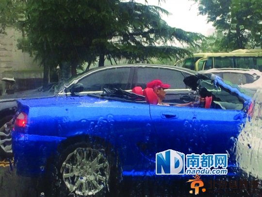 昨日，成都一名驾敞篷车的男子在雨中行驶，被众多网友抓拍并发上微博。图片来源：四川在线