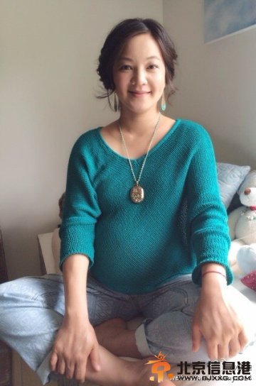 阿雅挺大肚盘腿而坐面孔圆润气色好（图）