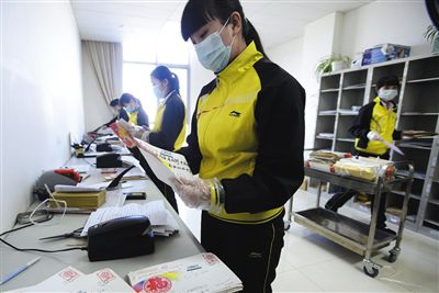 工作人员戴着手套和口罩处理群众来信。