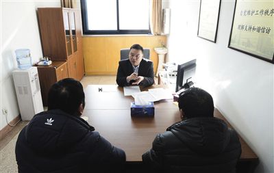 接谈室内，两名来访人员正在与工作人员接谈。