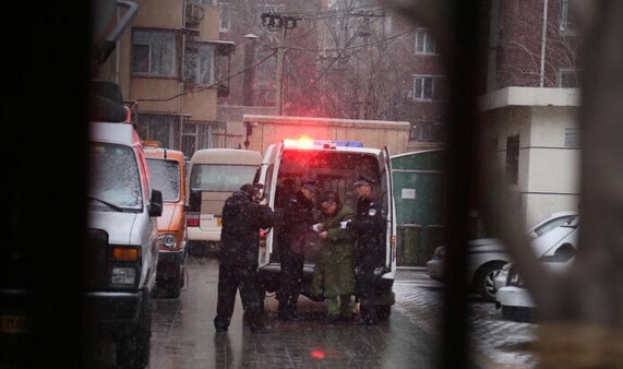 尹相杰穿军绿色大衣进入法庭受审