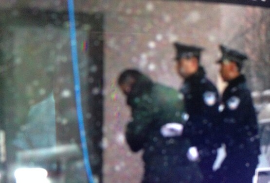 尹相杰穿军绿色大衣进入法庭受审