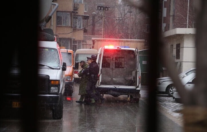 尹相杰穿军绿色大衣进入法庭受审