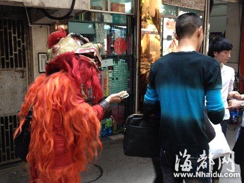 男子街头“舞狮”乞讨 店家不给钱便赖着不走