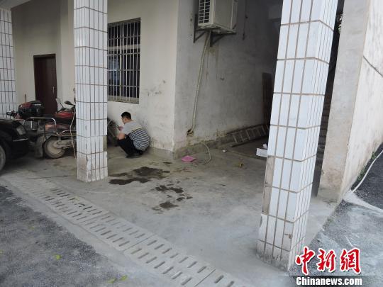 图为该男子蹲在墙角处专心上网。 刘洋 摄